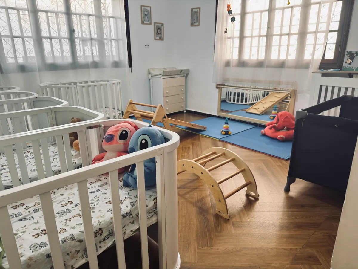Cots, a wooden climbing arch and mats in a bright room.