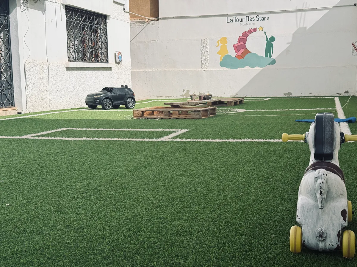 Outdoor yard with a ride-on rocking horse and the nursery mural.