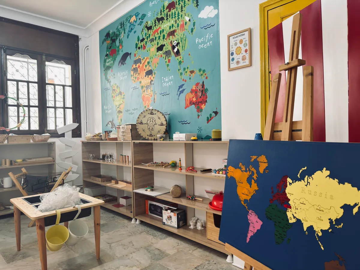 World discovery corner: a wall map, a continent puzzle on an easel and shelves of materials.